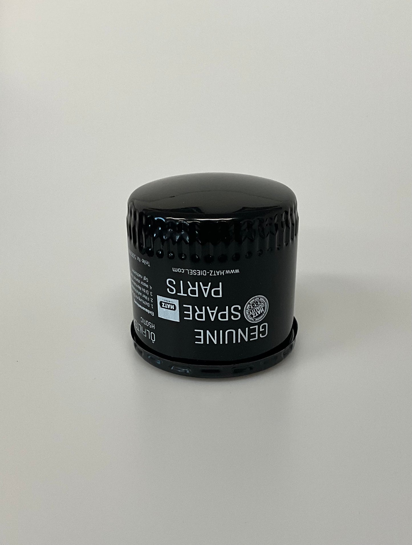 A black Genuine Hatz oil filter on a light grey background.