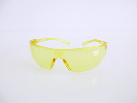 Yellow safety glasses with a translucent yellow frame and yellow-tinted lenses, displayed on a clean white reflective surface.