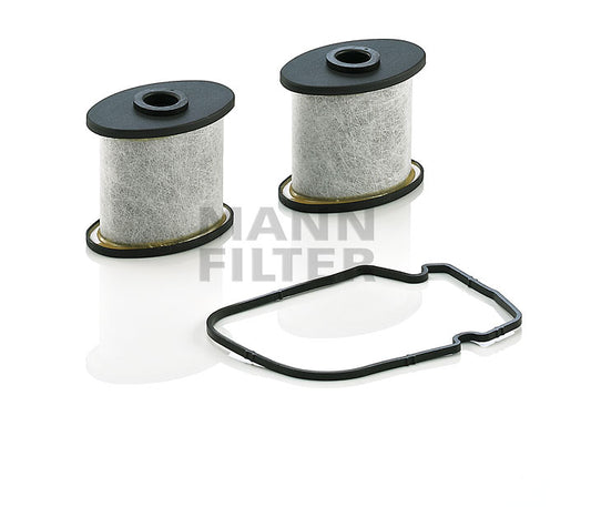 Two cylindrical ventilators, with black tops and bottoms, shown alongside a black rubber gasket on a white reflective background. A semi-transparent 'MANN FILTER' logo watermark is visible in the centre.