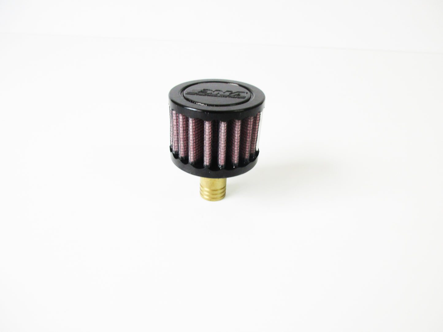 A small cylindrical crank case vent with a black top cap, red pleated media, and a brass-coloured bottom fitting, photographed on a plain white background.