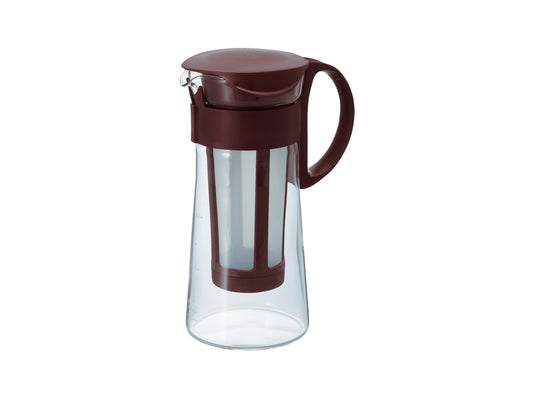 A clear glass cold brew coffee pitcher with a dark reddish-brown plastic lid, handle, and filter insert, shown on a plain white background.