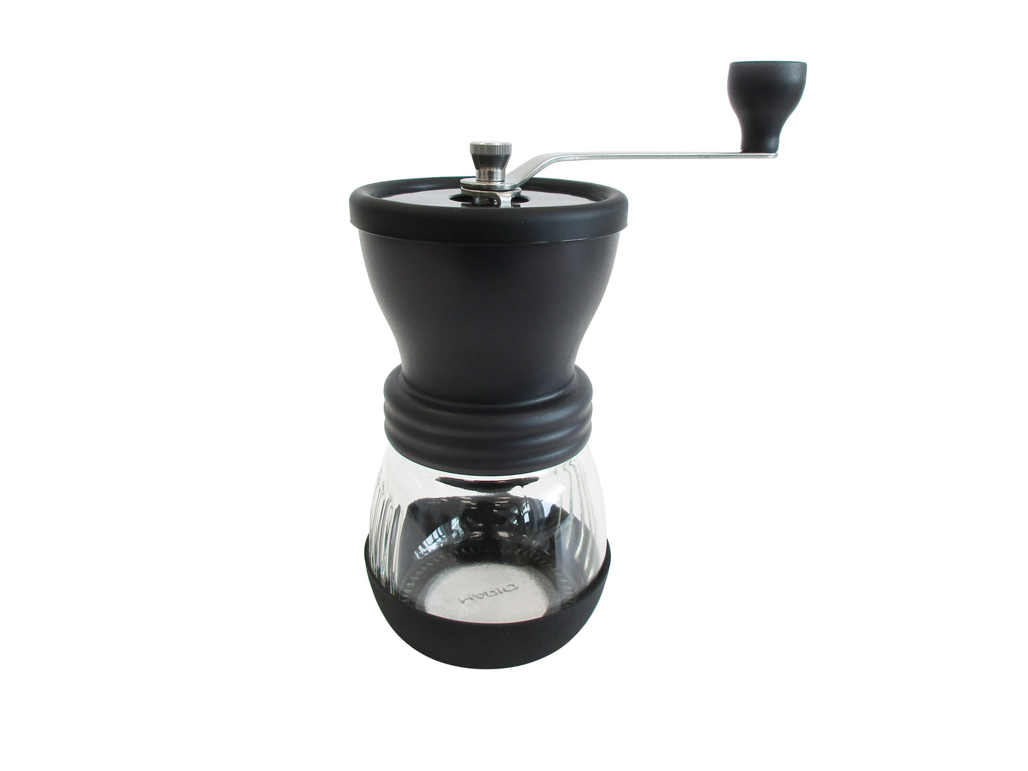 A manual coffee grinder with a matte black body, a clear glass carafe, and a silver metal hand crank, shown against a plain white background.
