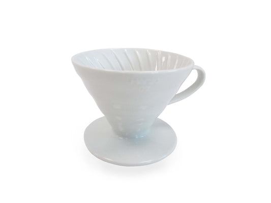 A white ceramic pour-over coffee dripper with a conical shape, ribbed inner walls, a side handle, shown on a plain white background.