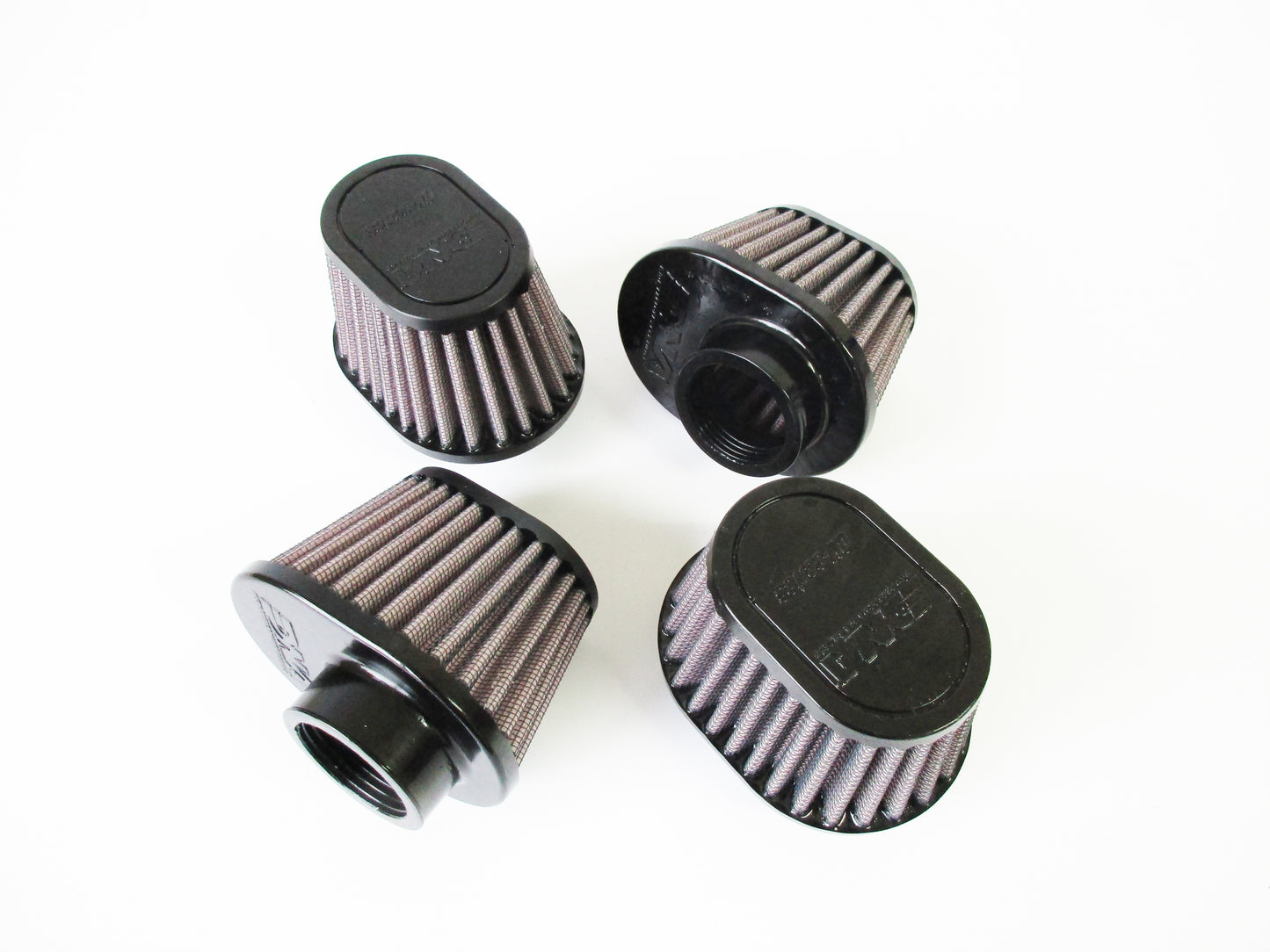 Four universal air filters with black tops and pleated filter media, arranged on a plain white background.