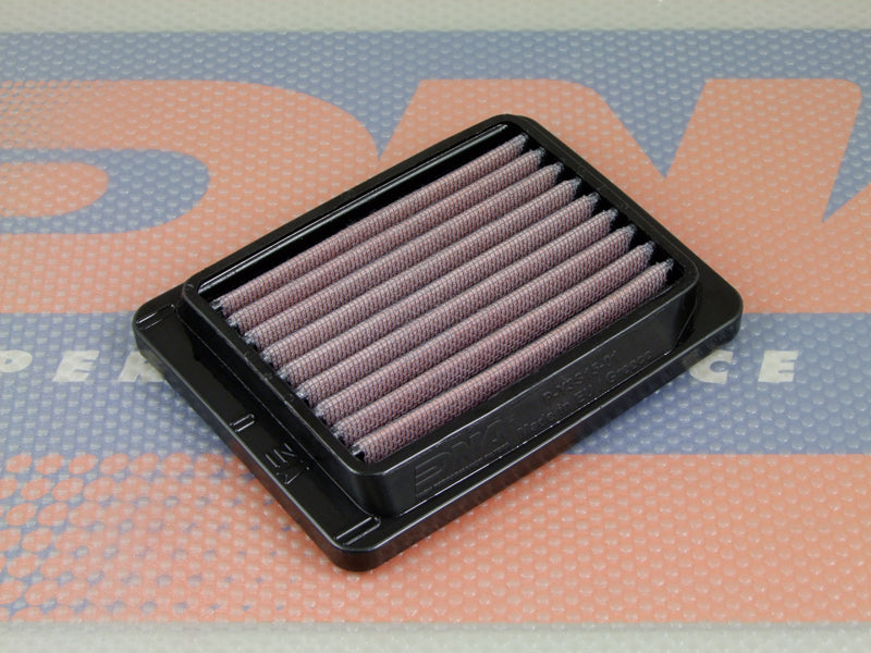 A rectangular motorcycle air filter, with a black PU frame,  and pleated red filter media, shown on a branded DNA high performance orange and blue mat.