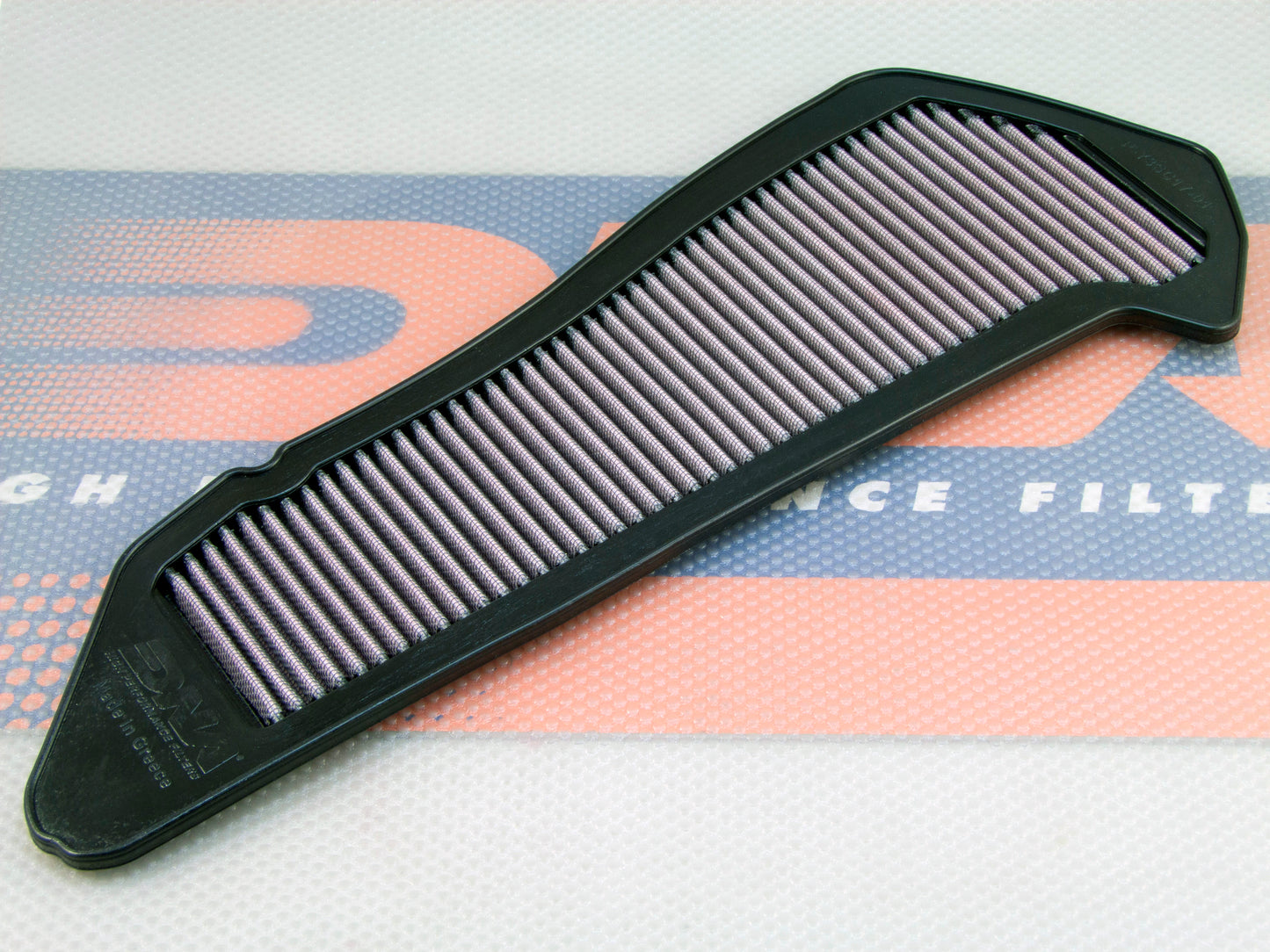 A black PU motorcycle air filter, with pleated filter media, shown diagonally on a branded blue and orange filter mat.
