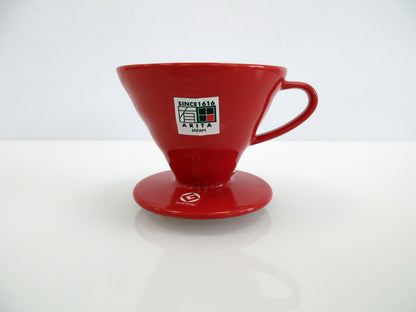A red ceramic pour-over coffee dripper, featuring a white 'Since 1916 Arita Japan' sticker on the front, set against a clean white background.