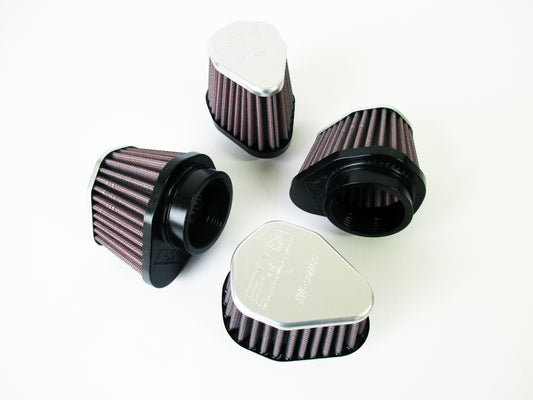 Four universal air filters with grey metal tops and pleated media, arranged on a plain white background.
